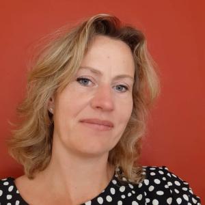 Foto von Susanne Profous vor einer roten Wand.